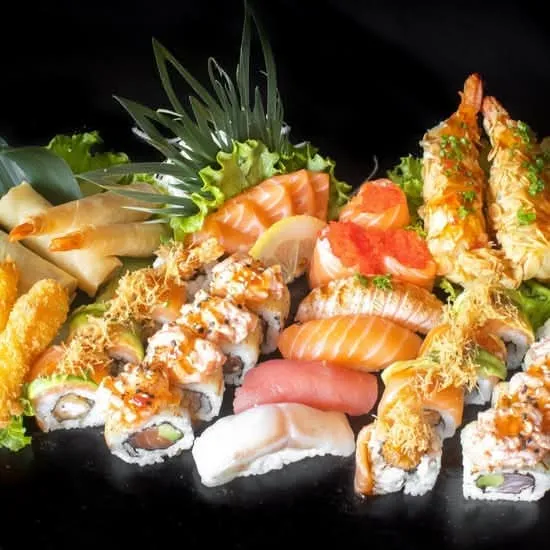 8 unidades de dragon roll, 8 uramaki salmão e abacate com molho doce picante, 4 nigiri sortido, 3 gunkan salmão e ovas, 5 sashimi salmão, 4 camarão panado, 2 crepe vegetais, 2 crepe de camarão e 2 gambas com amêndoa